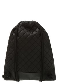 Czarny plecak ze skóry pikowanej z ściągaczem, ozdobiony skórzanymi elementami i teksturowanymi pomponami u podstawy. Kompaktowy, miękki i lekki design.