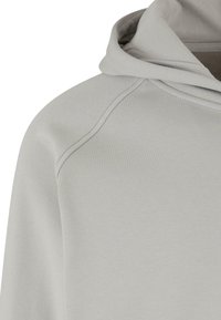 Lys grå hettegenser med en glatt tekstur, raglanermer og rund hals, med et minimalistisk design.