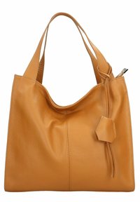 Tan leren tote bag met een zachte textuur, brede schouderbanden en een subtiel verzameld ontwerp. Beschikt over een decoratieve strik en kleine labeldetails.