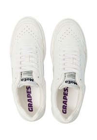 Hvite lær sneakers med perforert tå, flate hvite lisser og lilla merkeinnside. Teksturert såle og minimale design detaljer.