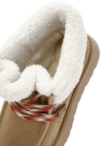 Zimowe buty w kolorze brązowym, z miękkim, białym sztucznym futrem, teksturowanym zwrótem z zamszu oraz dekoracyjnymi czerwono-białymi sznurówkami w wzory.