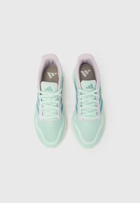 Par lagano mint zelene mrežaste trkaće cipele sa bijelim potplatima i vezicama, prikazane iz ptičje perspektive na bijeloj pozadini.