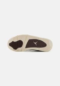 Suela de zapato con material de goma, predominantemente beige con acentos oscuros, patrón de agarre texturizado y un logo en el centro.