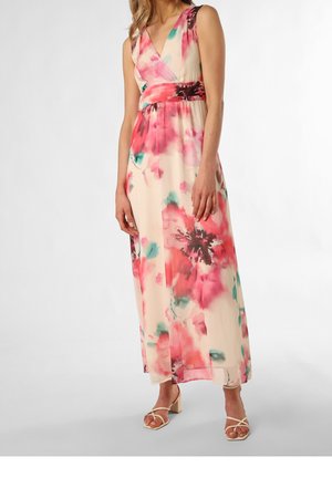 Femme portant une robe maxi sans manches à imprimé floral aux couleurs rose, rouge et bleu sarcelle, ainsi que des sandales à talons blocs ouvertes beiges.