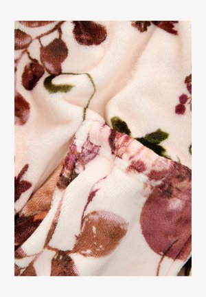 Blommönstrad plyschtyg med rosa, bruna och gröna nyanser; mjuk textur med en vikt kant som visar livfulla blommönster.