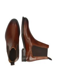 Botas Chelsea de cuero marrón con paneles elásticos laterales, puntera redonda y tirador. Textura suave y tacón bajo apilado.