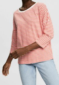 Pruhovaná dlouhá košile s rukávy v korálové a bílé barvě, s lodním výstřihem, volným střihem a měkkou bavlněnou tkaninou.