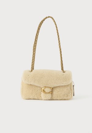 Bēšs plīša rokassomas ar mīkstu faktūru, zelta ķēdes siksniņu un priekšējā atloka ar zelta apaļu aizdari. Kompakta taisnstūra forma.