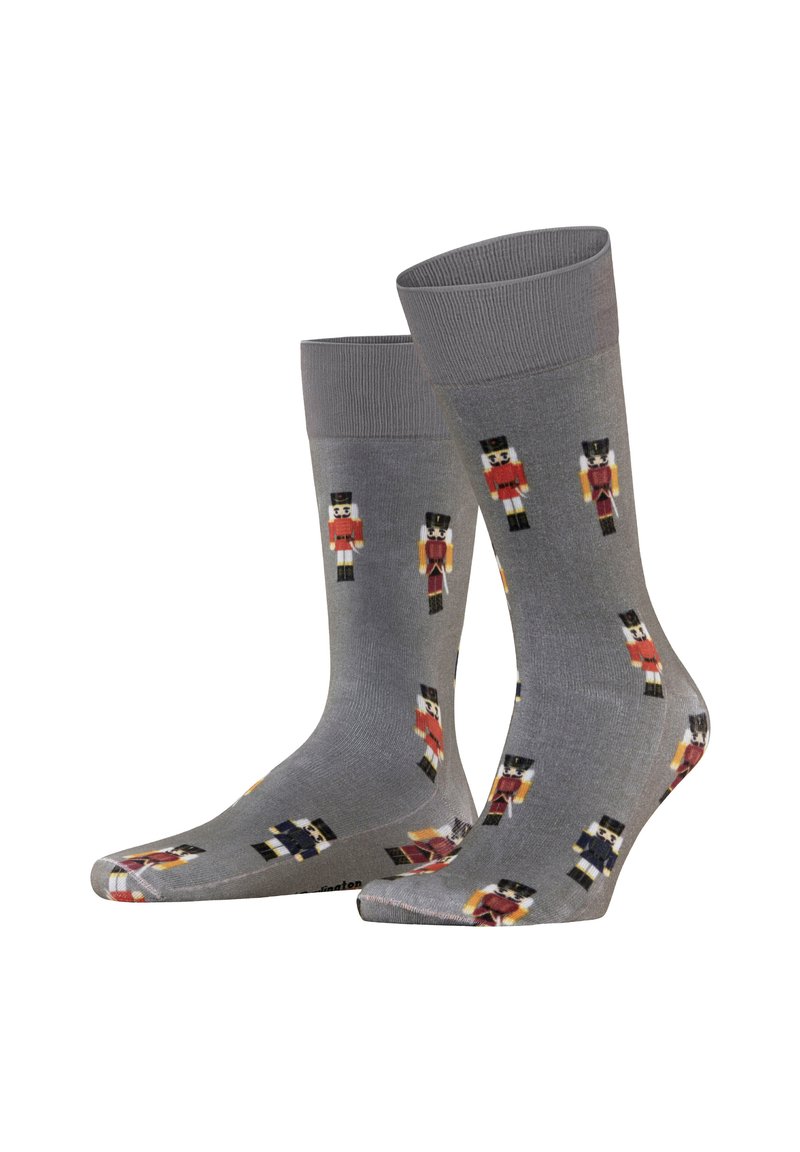 Calzini grigi con un motivo di nutcracker ripetuto in rosso, nero e bianco. Tessuto liscio, lunghezza fino al polpaccio e polsini a coste.