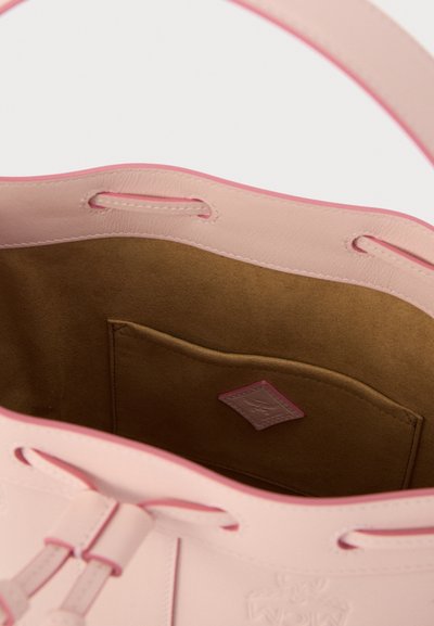 Εσωτερικό ροζ δερμάτινης τσάντας με απαλό καφέ φόδρα, που διαθέτει πλαϊνή τσέπη και διακοσμητικό ράψιμο κατά μήκος της άκρης.