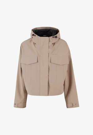 Veste beige coupée avec capuche, dotée de deux grandes poches poitrine, de coutures verticales et de poignets boutonnés pour un ajustement modifiable.