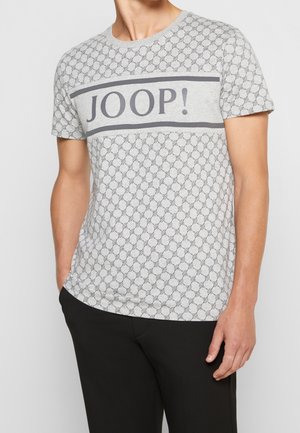 T-shirt gris à manches courtes avec un motif géométrique noir, comportant une bande grise horizontale sur la poitrine avec le texte "JOOP!" en noir.