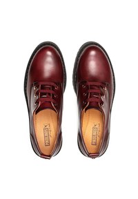 Chaussures en cuir bordeaux avec des orteils ronds, un laçage et une semelle en caoutchouc noir texturé. L'intérieur est doté d'une doublure en cuir beige.