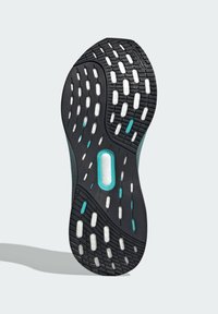 Suola di sneaker in gomma nera con motivi di trazione bianchi e turchesi. Presenta un'incisione centrale e una superficie testurizzata per una migliore aderenza.