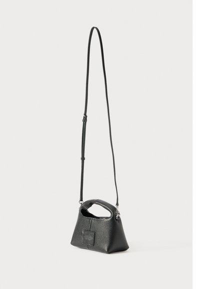 Kleine zwarte handtas van textuurleer met korte bovenhandgreep en lange verstelbare schouderband op een witte achtergrond.