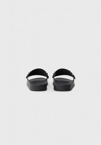 Sorte sandaler med flad sål, åben bag og to brede stropper. Minimalistisk design med guldfarvede detaljer. Struktureret fodseng.