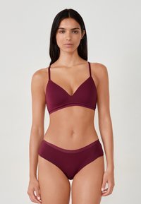 Set di reggiseno e mutandine bordeaux composto da un reggiseno triangolare con spalline sottili, tessuto morbido e un perizoma alto coordinato con bordo elastico.