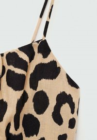 Majica s leopard uzorkom, s crnim mrljama na bež pozadini, s tankim naramenicama i teksturiranim materijalom. Prikaz izbliza dizajna.