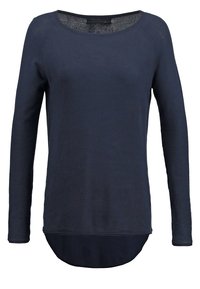 Haut à manches longues bleu marine avec un col rond, doté d'un ourlet arrondi et d'une texture douce. Coupe ajustable avec des accents côtelés aux poignets.