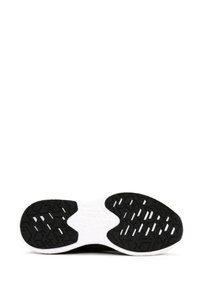 Sole di scarpa sportiva in bianco e nero con gomma nera testurizzata per la presa, dotata di un sottopiede bianco flessibile e motivi geometrici.