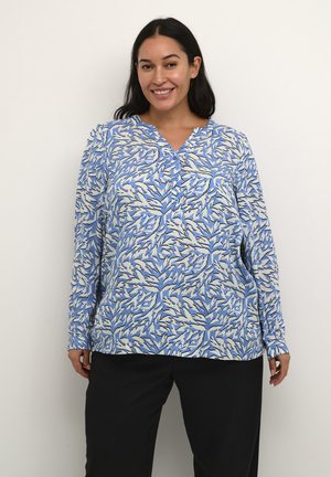 Cămașă cu mânecă lungă, cu un model abstract de frunze în nuanțe de albastru, alb și negru, cu închidere cu nasturi și croi lejer, asortată cu pantaloni negri.
