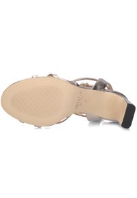 Sandal met hoge hakken en bandjes, met een metallic bovenwerk, open teen en textuurzool. Voorzien van een gemerkte voetbed en een stevige blokhak. Kleur: zilver.