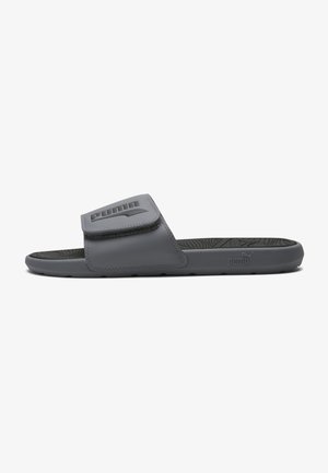 Sandale slide grise Puma avec bride réglable, semelle intérieure texturée et logo Puma sur la bride et le côté de la semelle.
