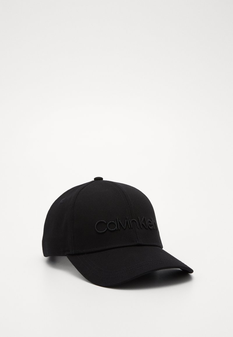 Casquette de baseball noire en tissu au toucher lisse. Présente un logo "Calvin Klein" brodé à l'avant. Design classique avec visière courbée.