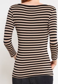 Pasiasty longsleeve z naprzemiennymi czarnymi i beżowymi poziomymi paskami, dopasowany krój i szeroki dekolt. Gładka tekstura materiału.