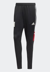 Svarta Adidas trackpants med vita ränder på sidorna, Adidas-logotyp på högra låret, röd och vit design detalj på vänstra benet.