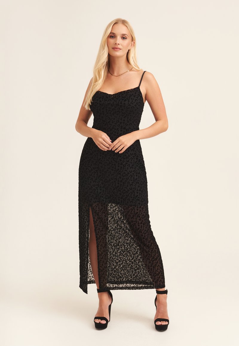 Black dress with a leopard print design, featuring thin straps, a fitted bodice, and a thigh-high slit. Made of sheer, textured fabric.