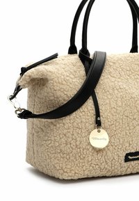 Beige textured fabric handbag with black leather accents, two top handles, and an adjustable strap. Features a round metal logo tag.
