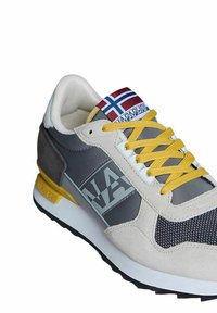 Sneaker grigia e beige con tomaia in rete, lacci gialli e linguetta decorata con una bandiera norvegese. Logo stampato sul lato.