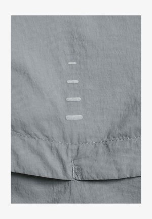 Tessuto grigio chiaro con una texture liscia presenta quattro segni bianchi orizzontali cuciti verticalmente, vicino al bordo inferiore, accentuati da una cucitura sottile.