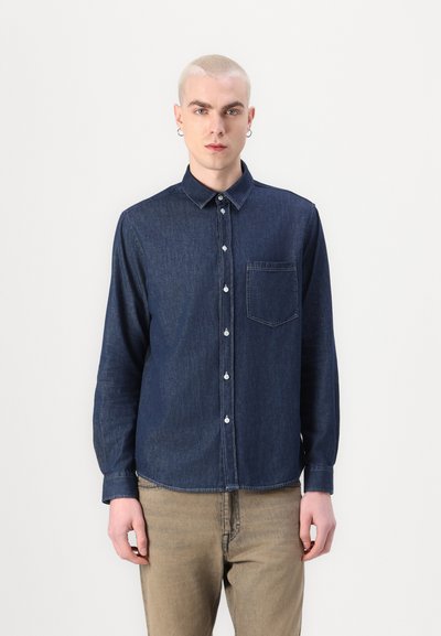 Chemise en denim foncé avec une fermeture à boutons à l'avant, col classique et poche poitrine. Elle possède des manches longues et un ourlet droit. Couleur uni marine.