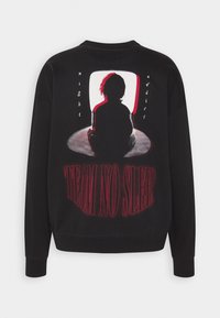 Sudadera negra con un gráfico de una silueta y el texto "EQUIPO SIN SUEÑO" en rojo y blanco, con una textura acogedora y suave.