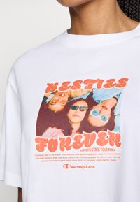 White cotton t-shirt featuring a colorful graphic print of three figures in sunglasses and the text "BESTIES FOREVER" in bold, retro font.