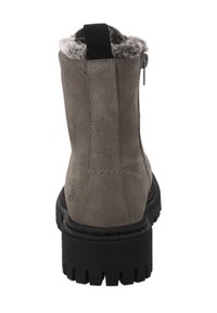 Grijze suède enkellaars met een zwarte rubberen zool, voorzien van een ritssluiting aan de achterkant en een voering van imitatiebont bij de kraag. Gestructureerde afwerking en logodetail.