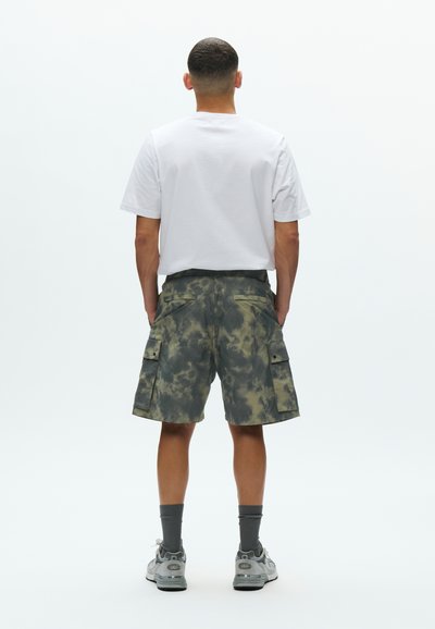 Cargo σορτς σε γκρι και ελιά μοτίβο tie-dye, κατασκευασμένα από ελαφρύ ύφασμα. Διαθέτουν πλαϊνές τσέπες και άνετη εφαρμογή. Συνδυασμένα με λευκό t-shirt.