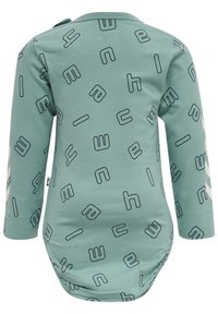Långärmad babybodysuit i mjuk teal-färgad tyg med ett lekfullt mönster av svart konturerade bokstäver. Tryckknappar vid axeln för enkel påklädning.