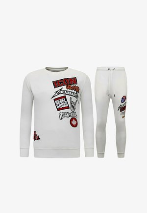 Witte sweatshirt en bijpassende joggerbroek met rode, zwarte en oranje rock-'n-roll-thema grafische tekst en symbolen aan de voorkant.