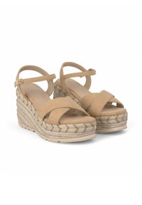 Sandalias de cuña beige con correas cruzadas y hebilla en el tobillo. Fabricadas en tejido suave; acentuadas con yute trenzado para añadir textura y diseño.