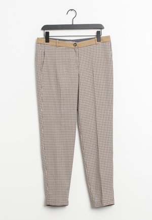 Beigen ja mustan ruudulliset kapenevat housut, joissa on vaaleanruskea vyötärönauha ja nappi, roikkuvat mustassa henkarissa valkoista taustaa vasten.