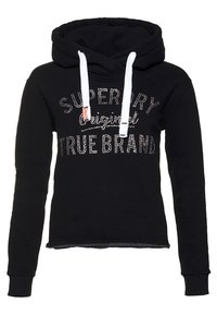 Svart huva med vita dragsnören och strass-text som står "Superdry Original True Brand" på framsidan.