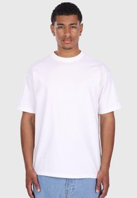 Hvid kortærmet t-shirt lavet af bomuld, med en klassisk rund hals og lige kant, bæres med lyseblå denim jeans.