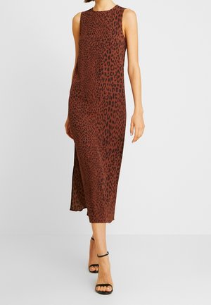 Ærmeløs brun midi-kjole med mørkt leopardprint båret med sorte højhælede sandaler med ankelrem på en klar baggrund.