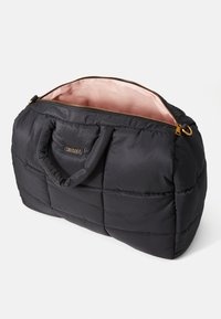 Black quilted soft tote bag with short handles, a gold zipper partially open revealing pink satin interior, and Twinset logo on front.