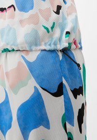 Kleurrijke, lichtgewicht stof met een mix van abstracte patronen in blauw, roze, groen en zwart, met een geplooide elastische taille en een verstelbaar trekkoord.