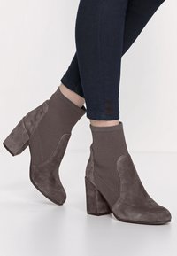 Szare botki za kostkę z połączeniem zamszu i teksturowanej dzianiny, z masywnym obcasem i elastycznymi panelami bocznymi dla dopasowanego fasonu.