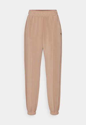 Beige sweatpants with an elastic waistband, tapered cuffs, and side pockets; soft texture with subtle vertical stitching accents.